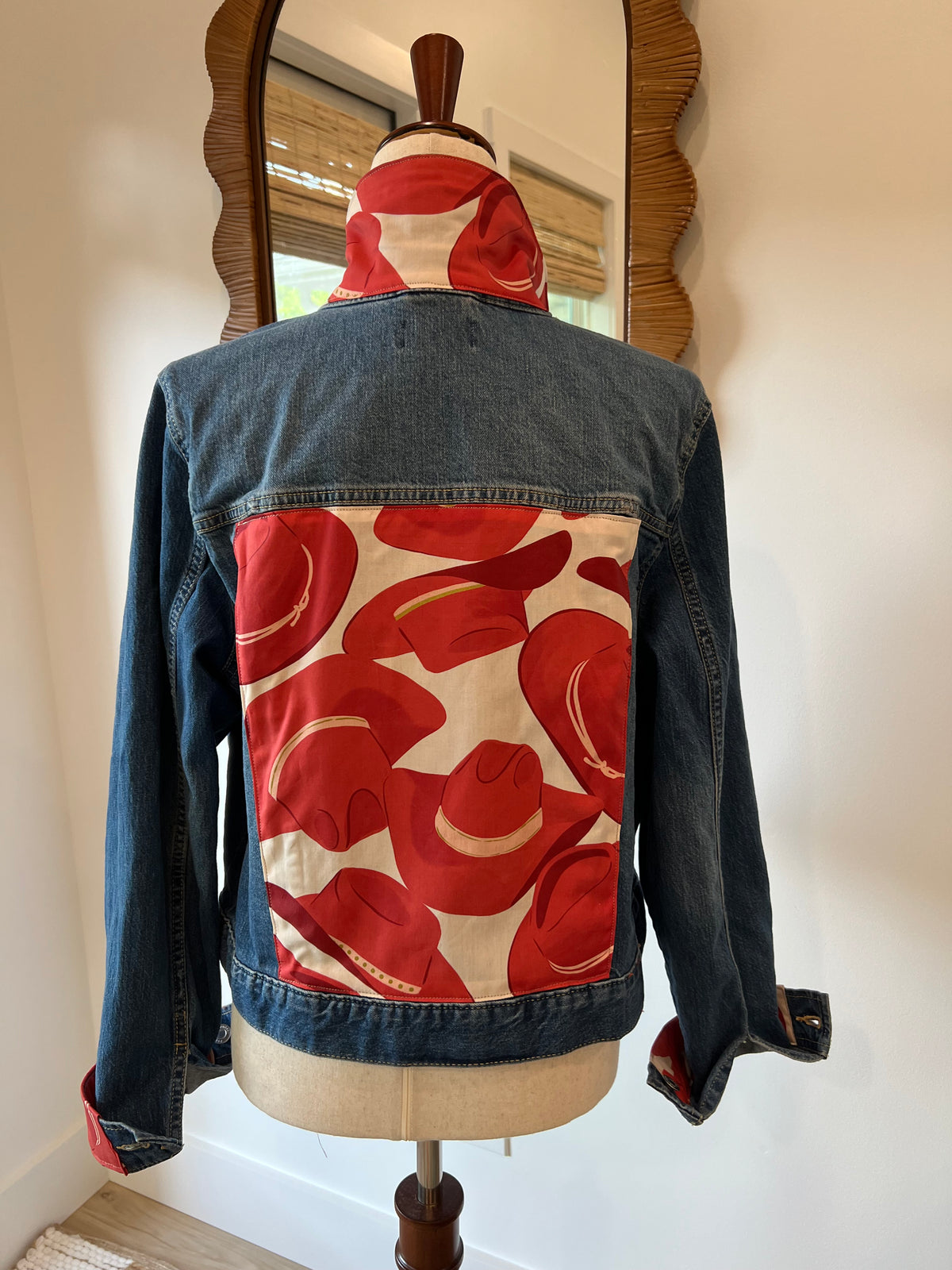Back of denim jacket with red cowboy-hat fabric panel and matching collar and cuffs