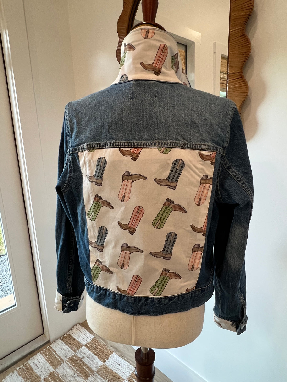 Back of denim jacket with pastel cowboy-boot print panel