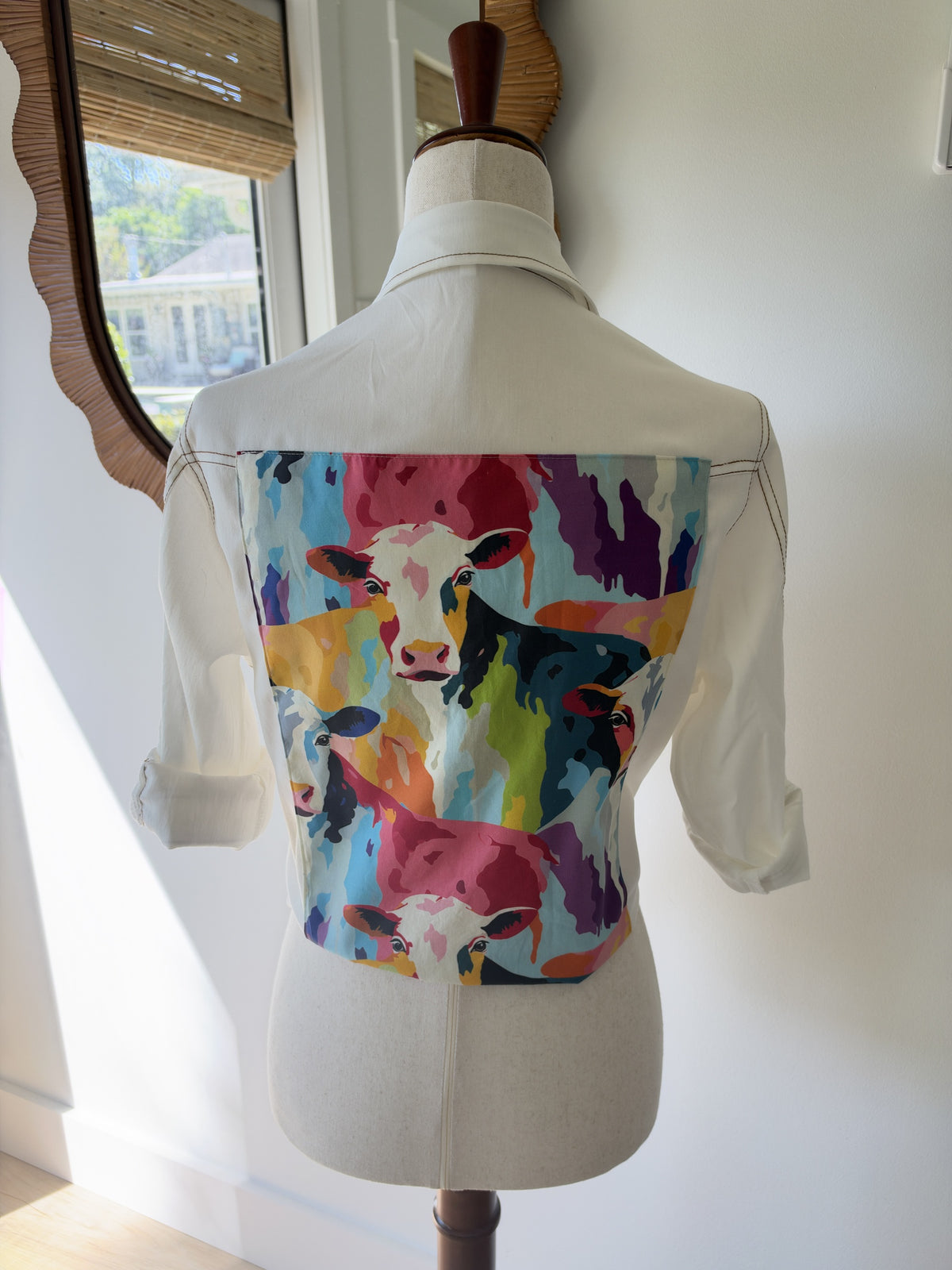 Back of white shirt with a colorful pop art cow fabric panel