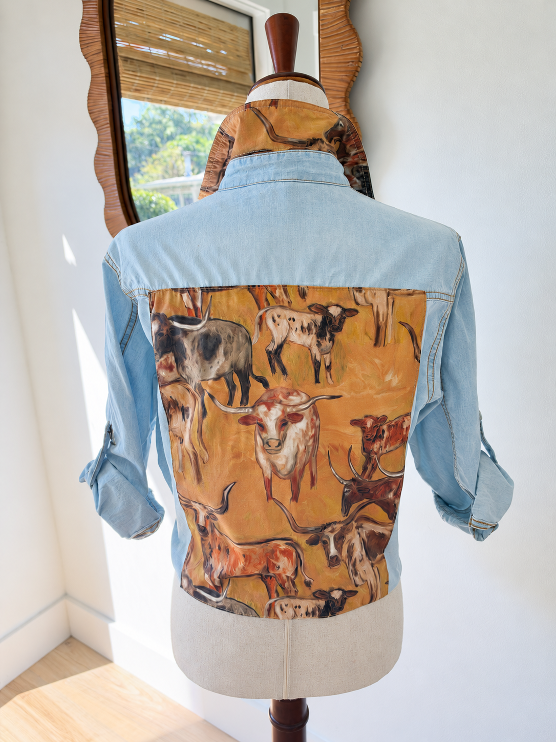 Back of light blue longhorn shirt showing the cattle-print fabric panel and coordinating collar