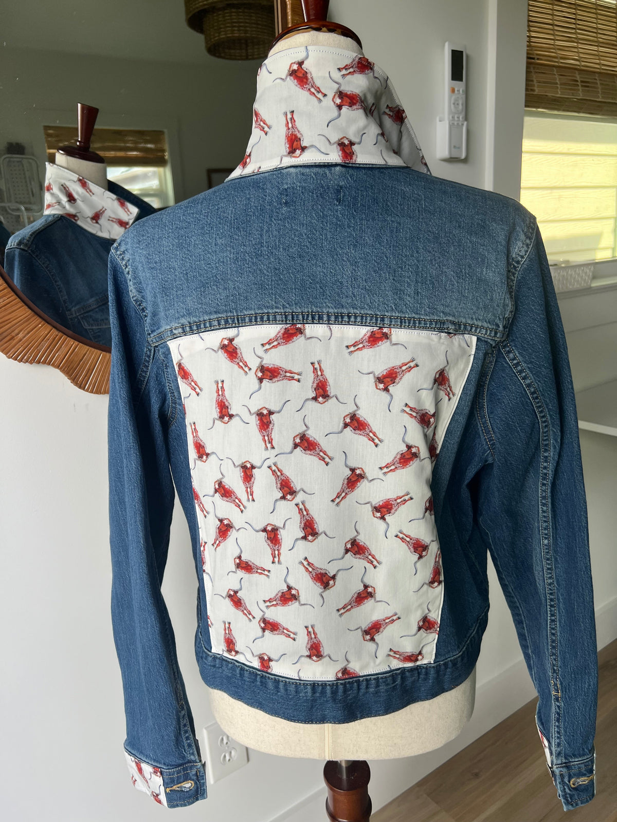 Back of Red Longhorn Denim Jacket on a dress form, showing the fabric panel and matching collar and cuffs
