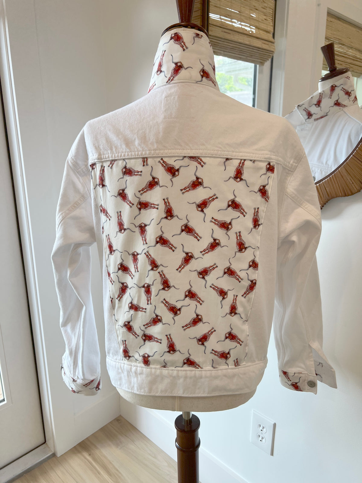 back view of white denim jacket with red longhorn print cotton detailing